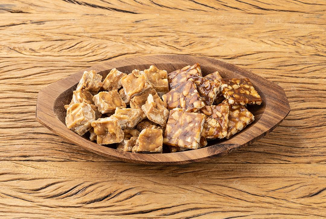 Pe de moleque, típico doce de amendoim brasileiro sobre mesa de madeira.