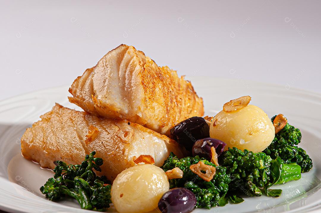 Peixe de bacalhau grelhado servido com brócolis, azeitonas pretas e assado