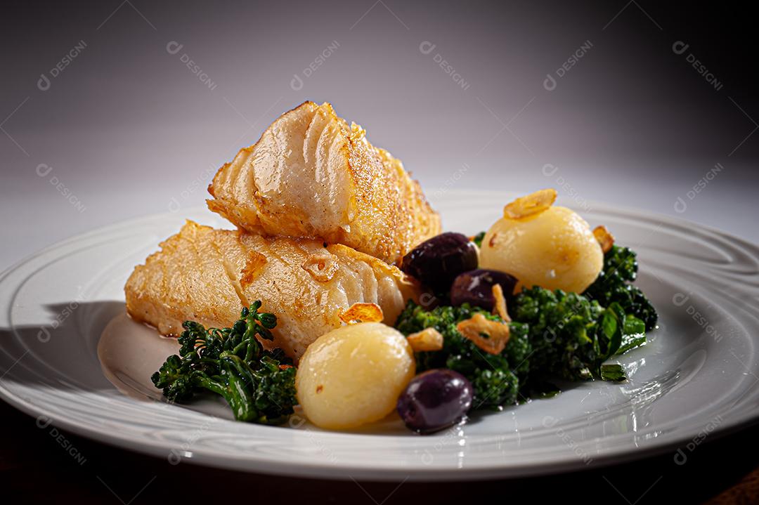 Peixe de bacalhau grelhado servido com brócolis, azeitonas pretas e assado