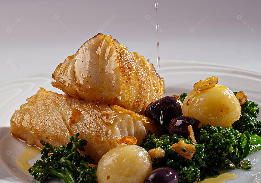 Peixe de bacalhau grelhado servido com brócolis, azeitonas pretas e assado