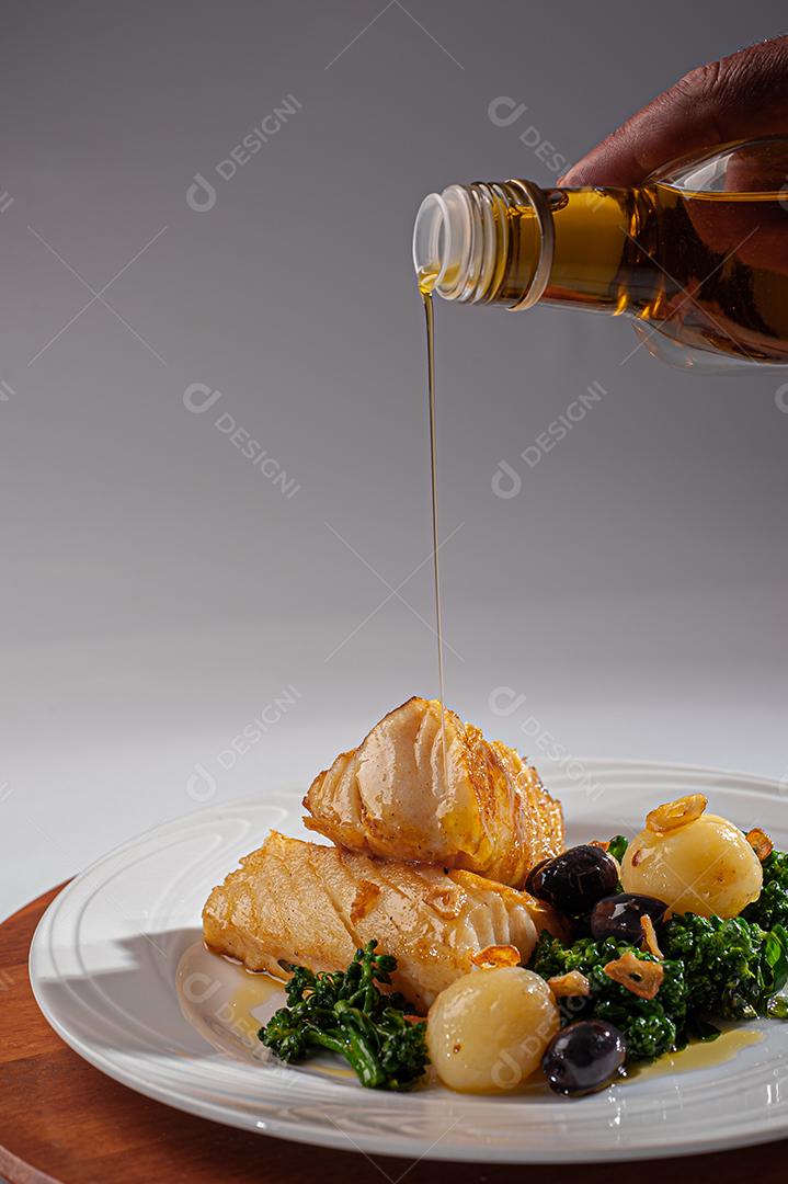 Peixe de bacalhau grelhado servido com brócolis, azeitonas pretas e assado