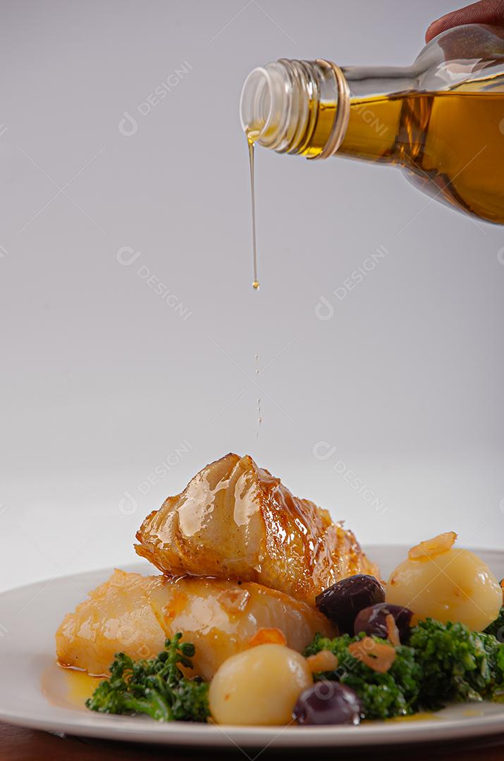 Peixe de bacalhau grelhado servido com brócolis, azeitonas pretas e assado