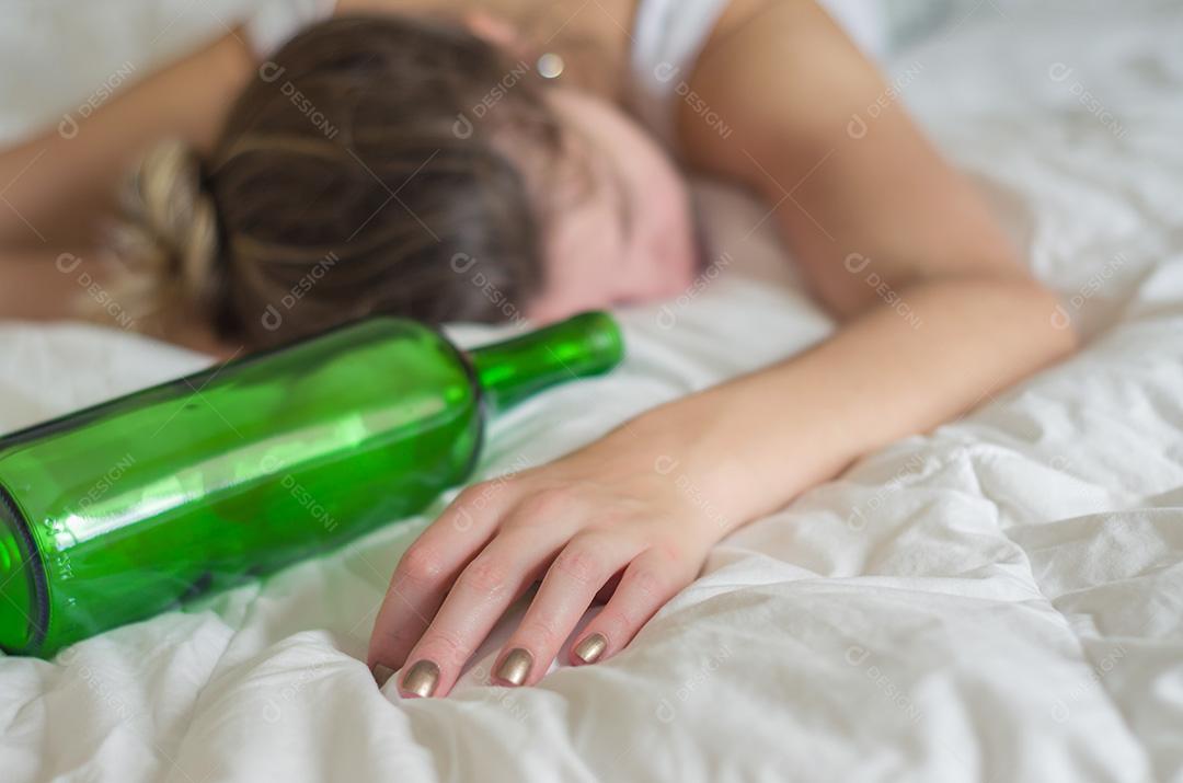 Grande conceito de abuso de álcool. Jovem, cabelos loiros, desmaiou