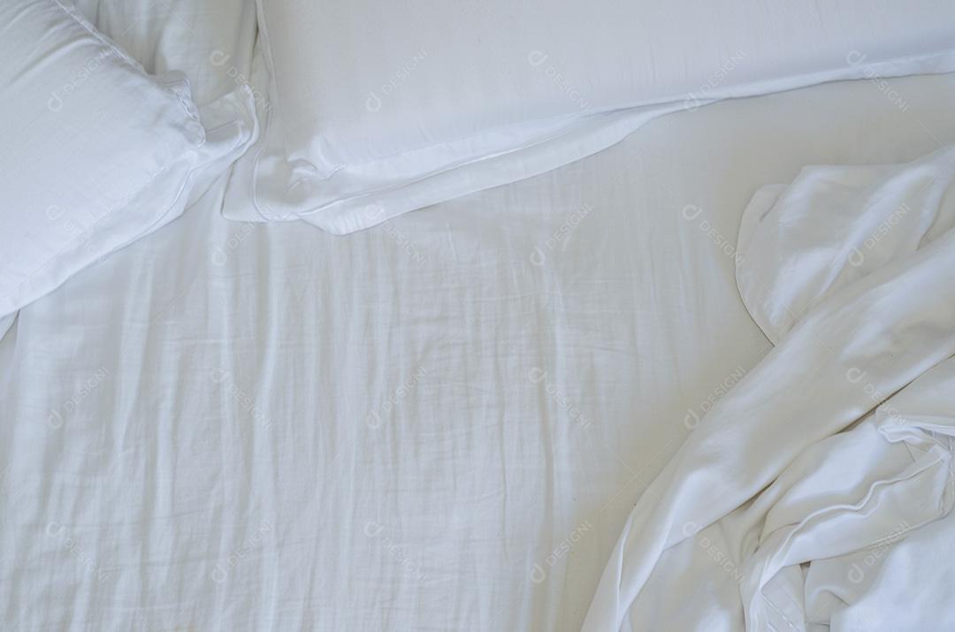 Grande conceito de cama bagunçada, despenteada, cama branca, lençol amassado.