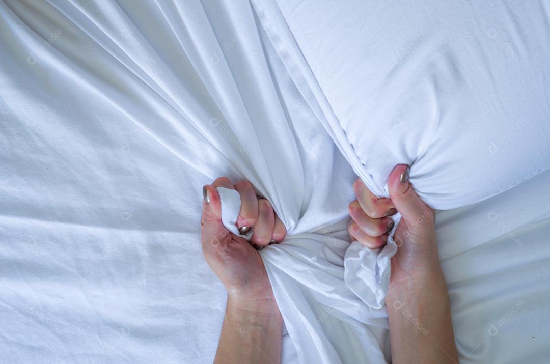 Orgasmo de sinal de mão de mulher na cama branca, mão de mulher puxando