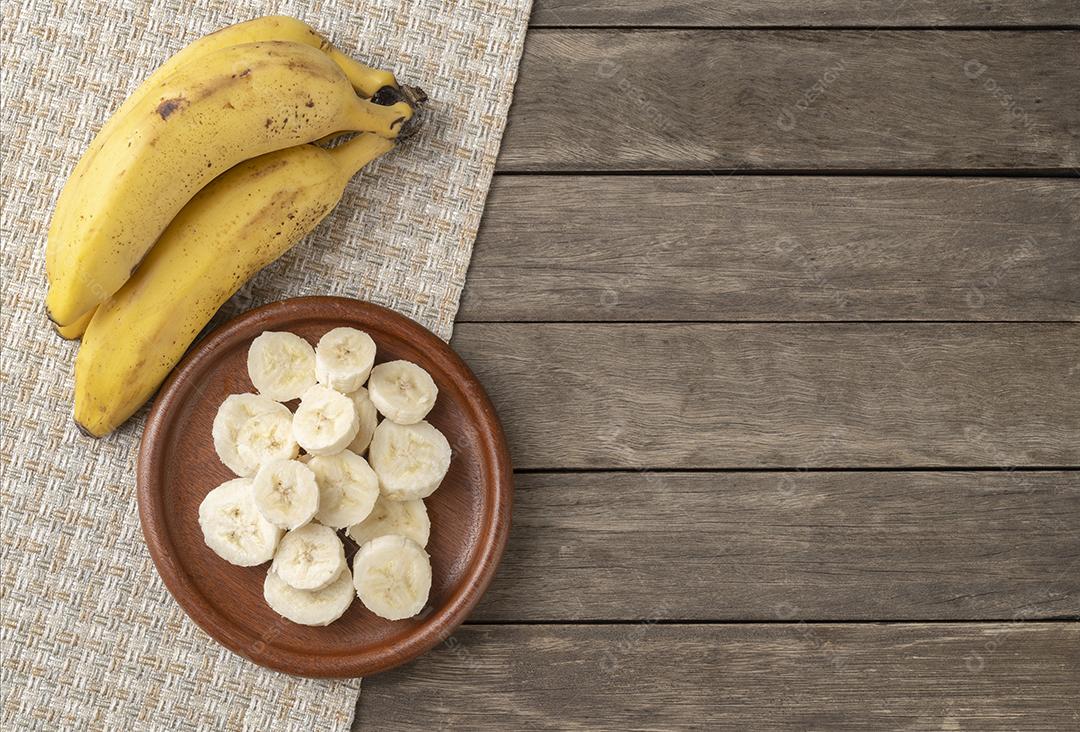 Bananas e fatias sobre mesa de madeira