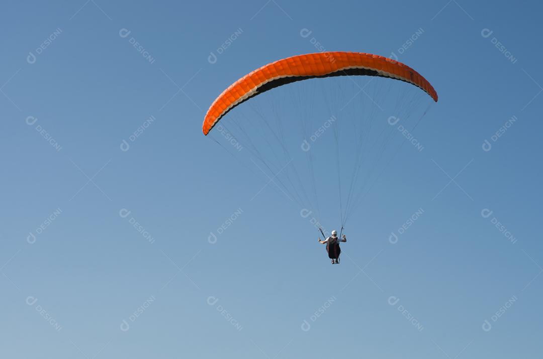 Estudantes praticando parapente na colina.