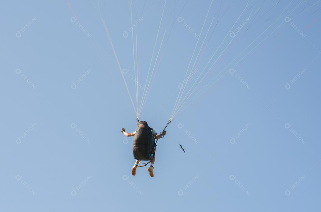 Estudantes praticando parapente na colina.