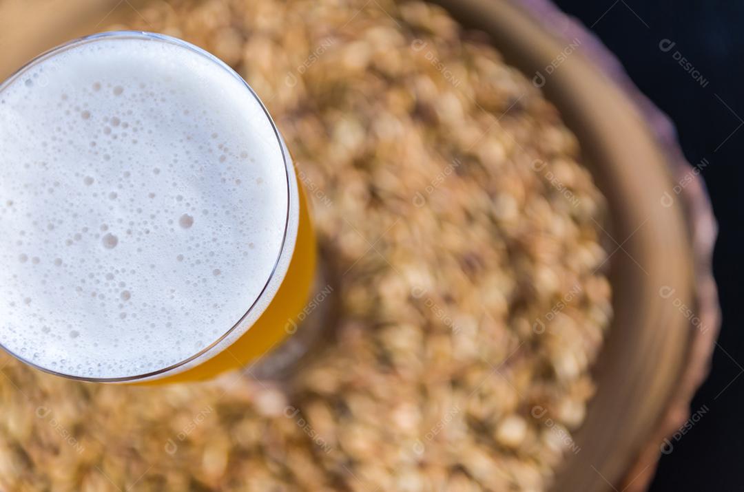 Copo de cerveja visto de cima com malte ao fundo