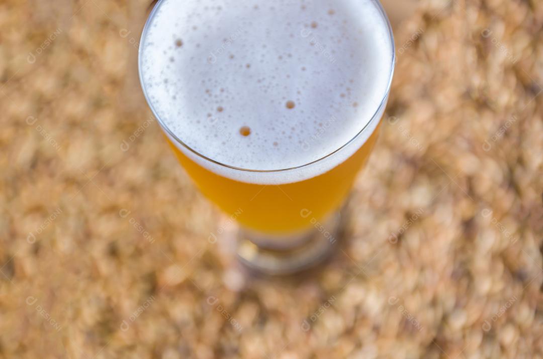 Copo de cerveja visto de cima com malte ao fundo