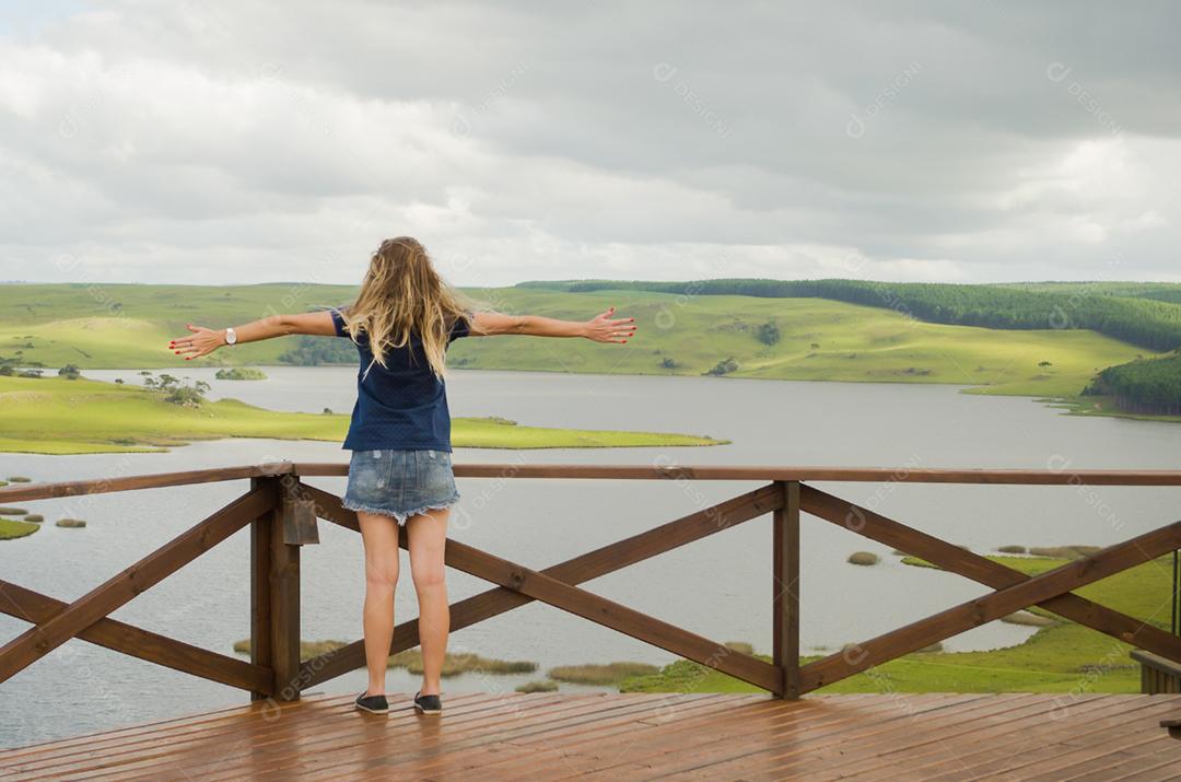 Grande conceito de liberdade, mulher de braços abertos para o horizonte.