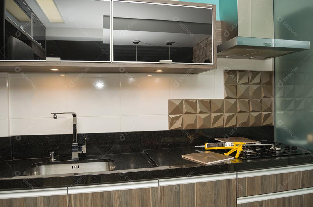 Renovando a cozinha, instalando azulejo na parede.