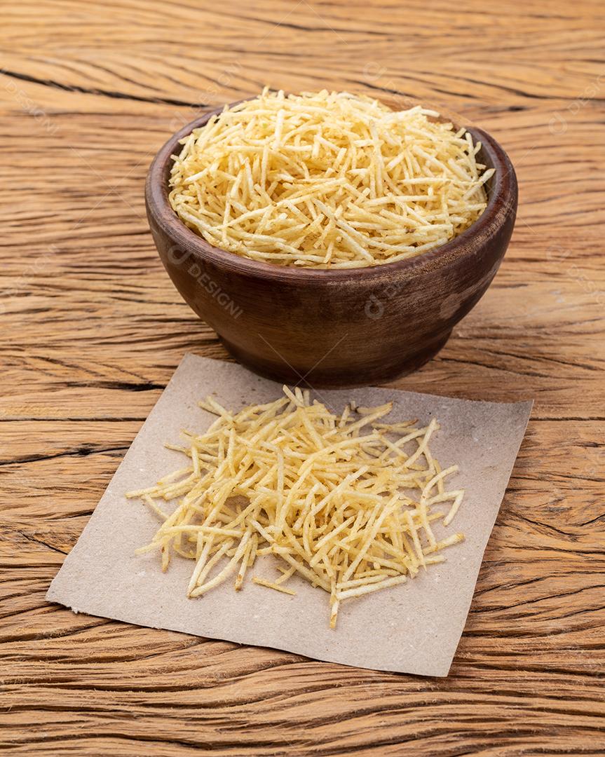 Palha de batata ou batata de sapato em uma tigela sobre mesa de madeira.