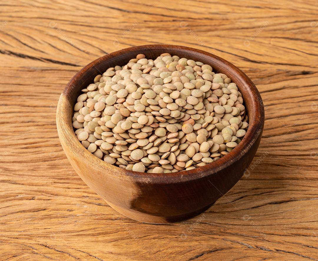 Lentilhas cruas em uma tigela sobre mesa de madeira