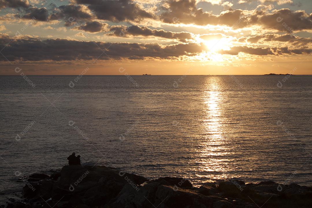 Casal ao pôr do sol sobre o Rio Prata em Colônia del Sacramento, Uruguai.