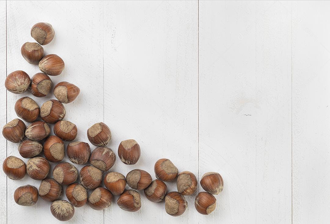 Um grupo de avelãs sobre mesa de madeira branca
