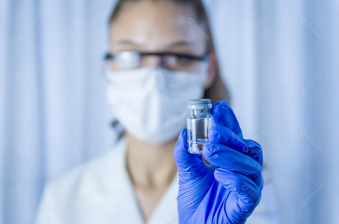 vacina nas mãos do pesquisador, médica segura seringa e garrafa com vacina para cura de coronavírus