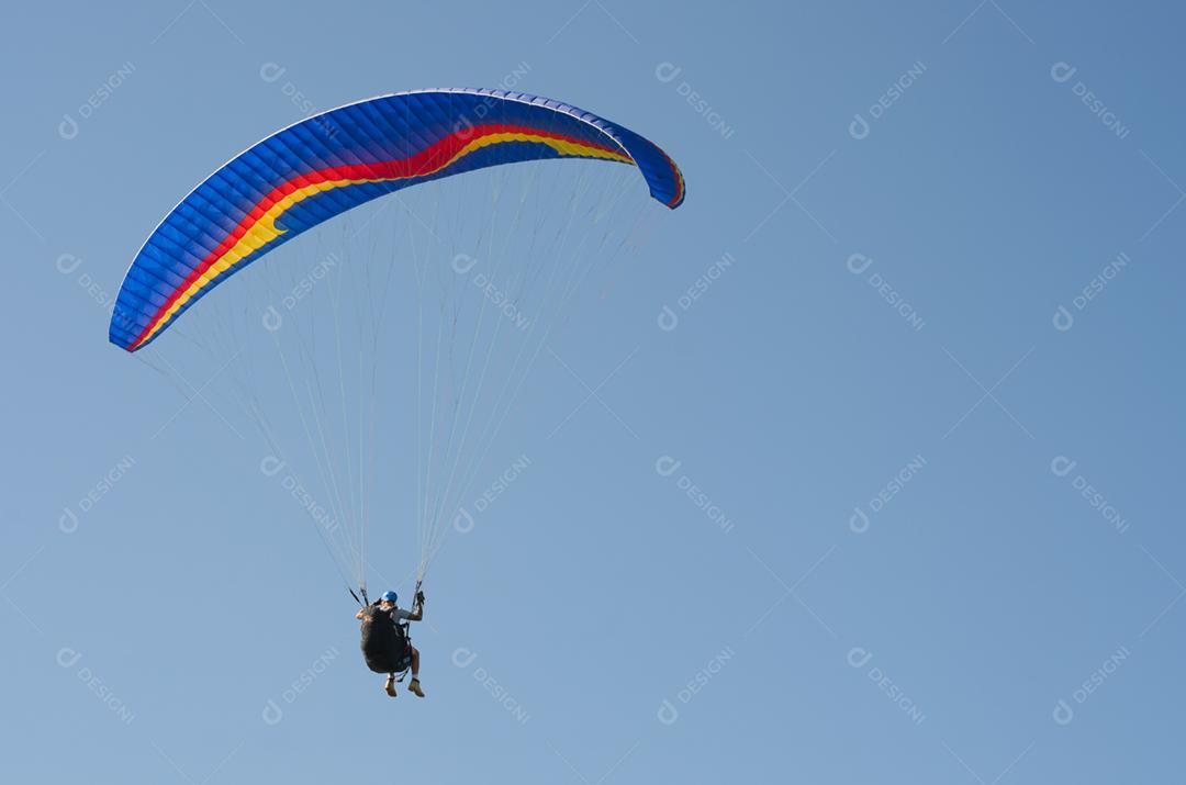 Estudantes praticando parapente na colina.