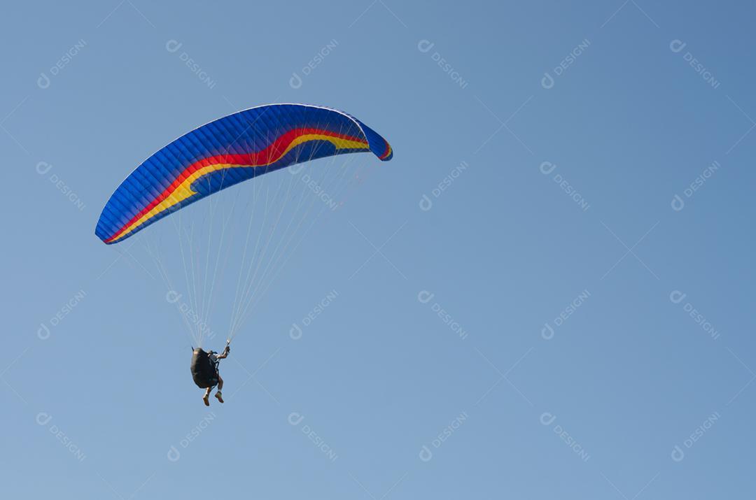 Estudantes praticando parapente na colina.