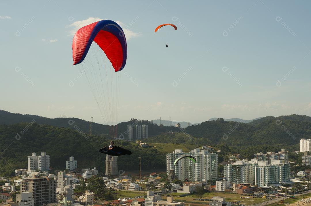 Estudantes praticando parapente na colina.