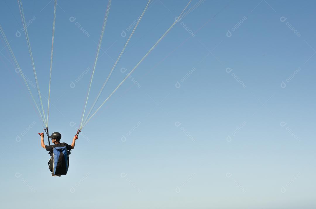 Estudantes praticando parapente na colina.