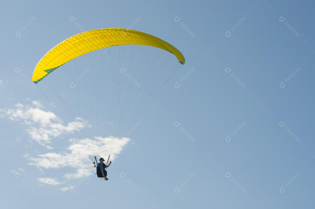 Estudantes praticando parapente na colina.