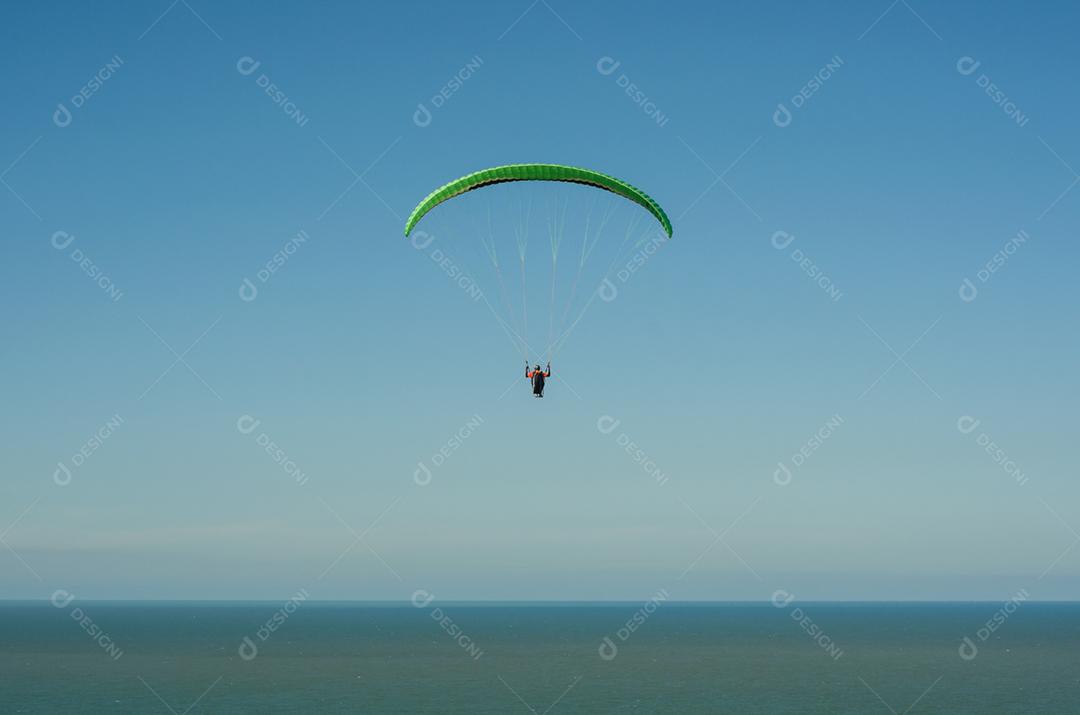 Estudantes praticando parapente na colina.
