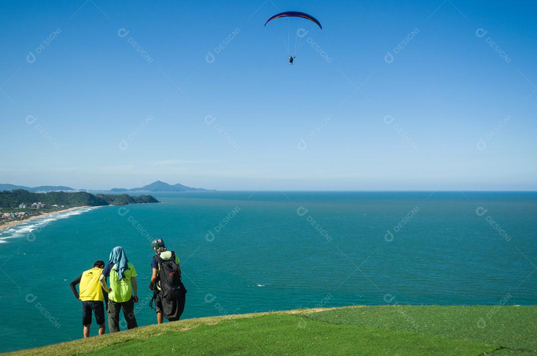 Estudantes praticando parapente na colina.