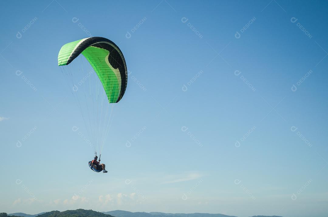 Estudantes praticando parapente na colina.