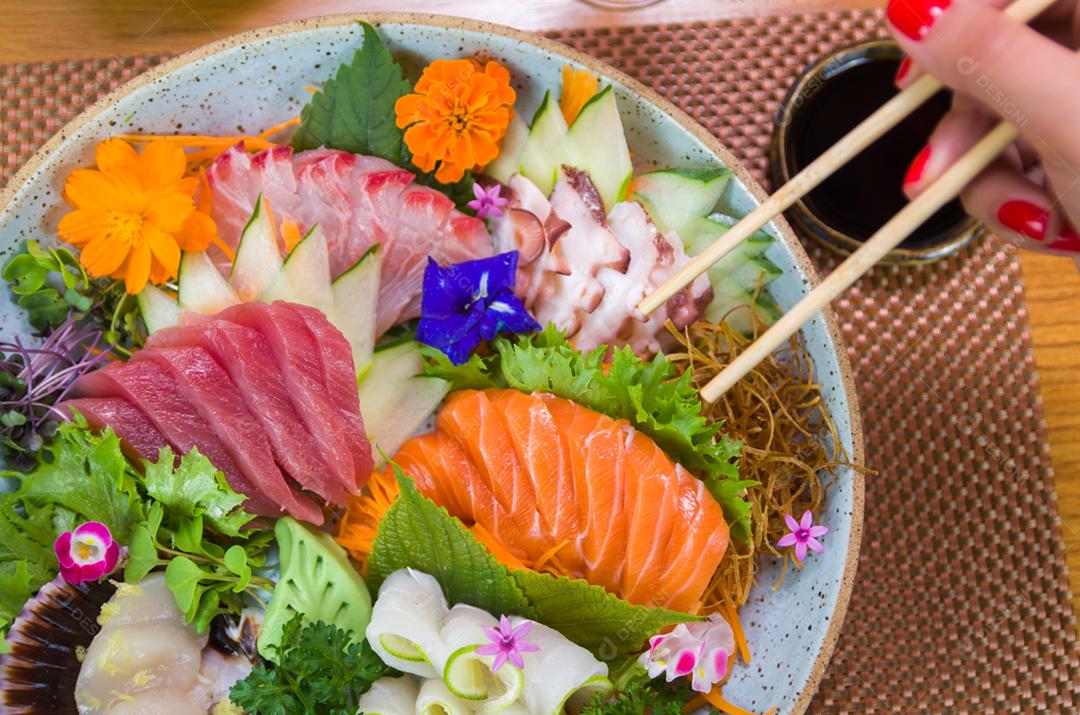 Woman eating delicious sushi, closeup on chopsticks