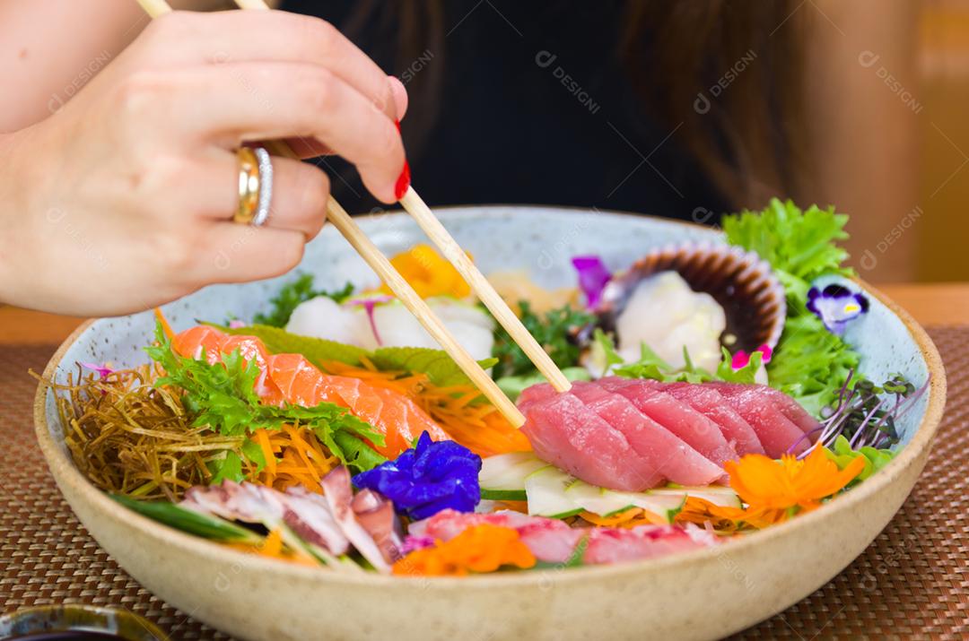 Mulher comendo sushi delicioso, closeup em pauzinhos