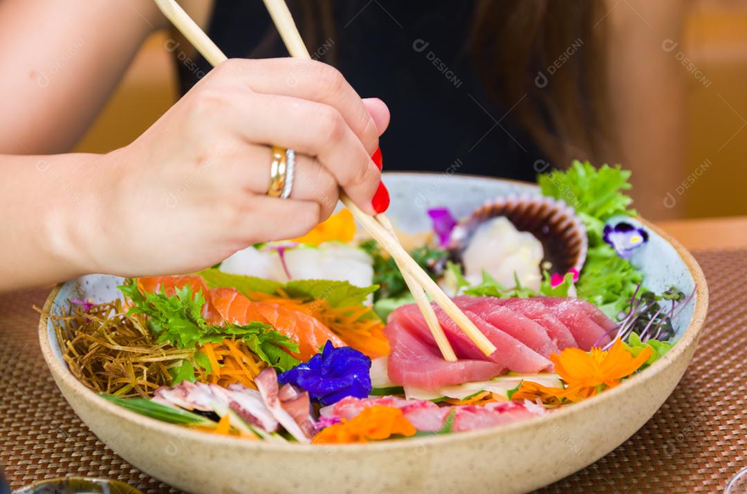 Mulher comendo sushi delicioso, closeup em pauzinhos