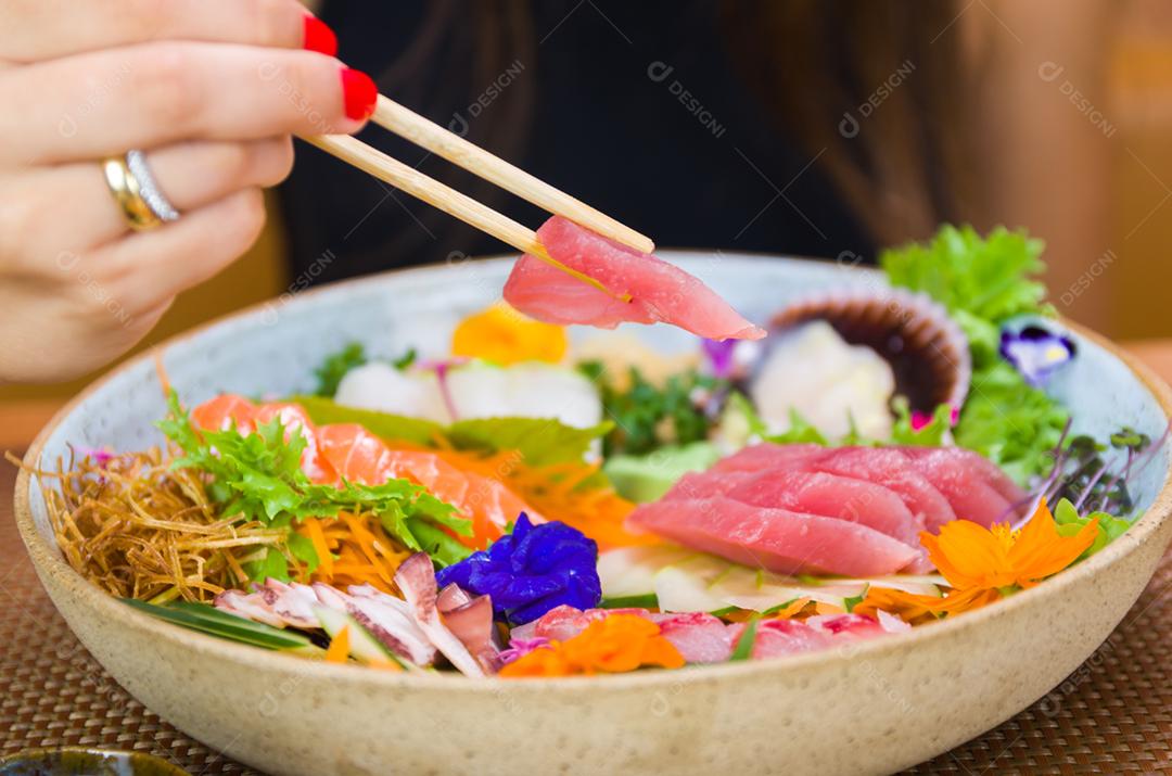 Mulher comendo sushi delicioso, closeup em pauzinhos