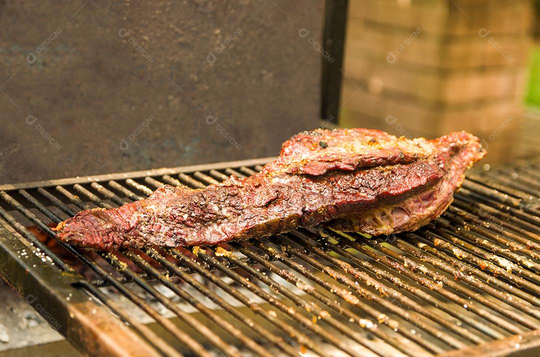 Exposição de carnes e legumes em um churrasco conhecido como Parrilla. T