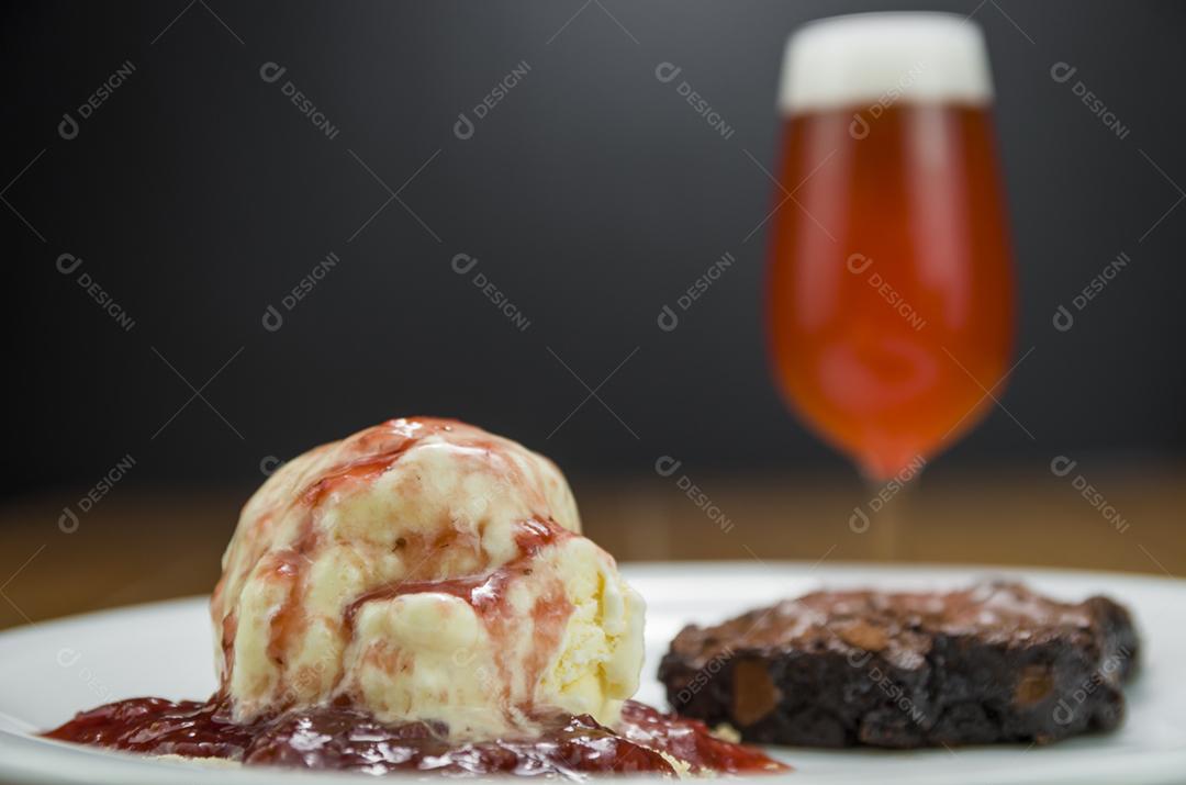 Deliciosa sobremesa de brownie de chocolate com sorvete de creme e cerveja de framboesa