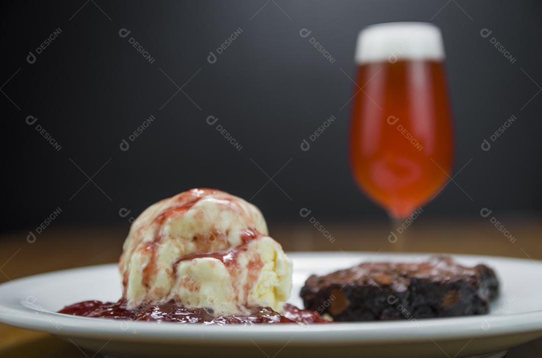 Deliciosa sobremesa de brownie de chocolate com sorvete de creme e cerveja de framboesa