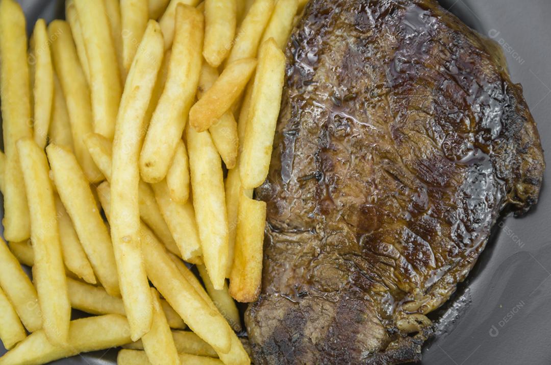 Delicioso prato de entrecosto grelhado com batatas fritas e copo de cerveja