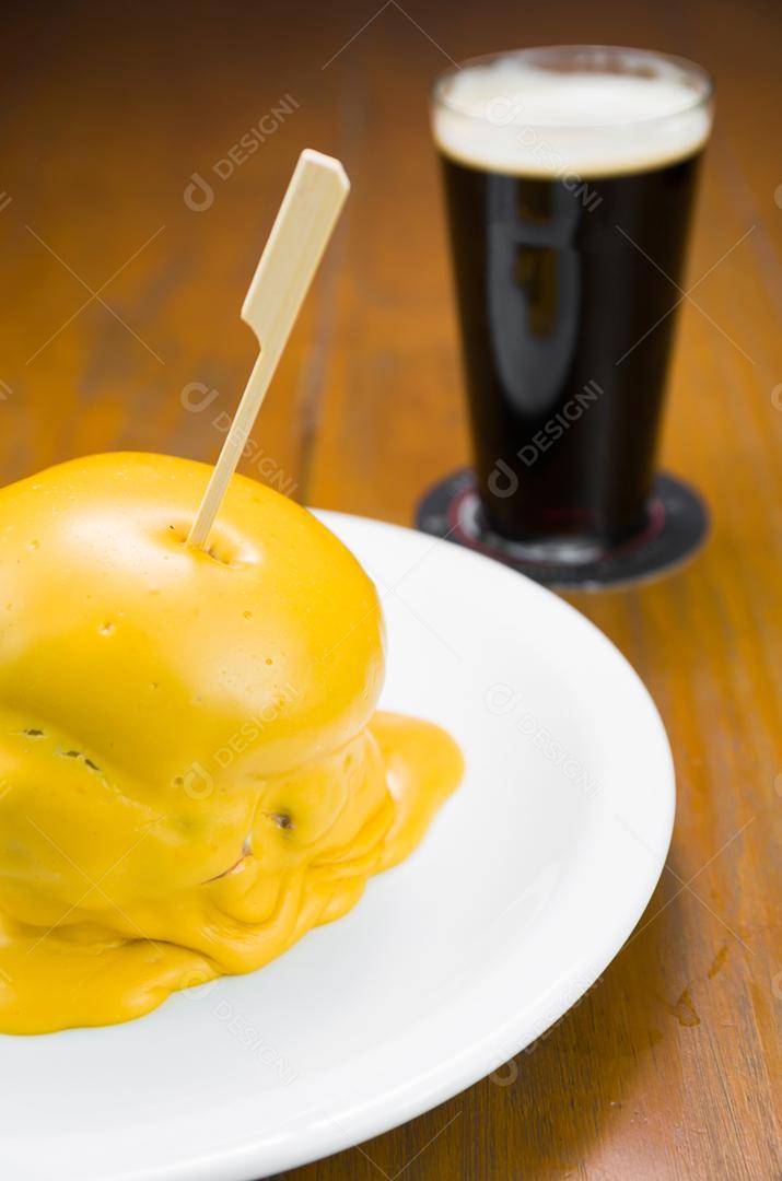 Delicioso close-up de hambúrguer coberto com molho de queijo cheddar