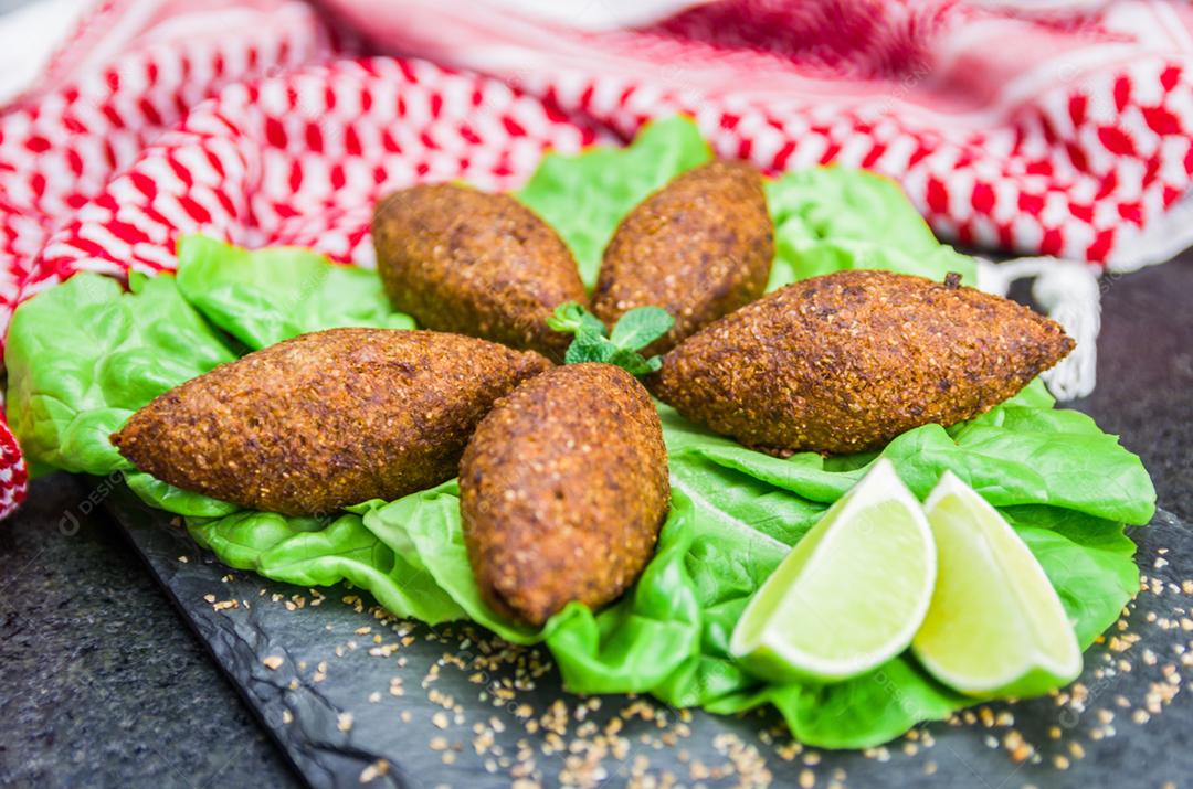 Deliciosa comida libanesa (árabe), quibe (kibe) com molhos e limão na pedra ardósia