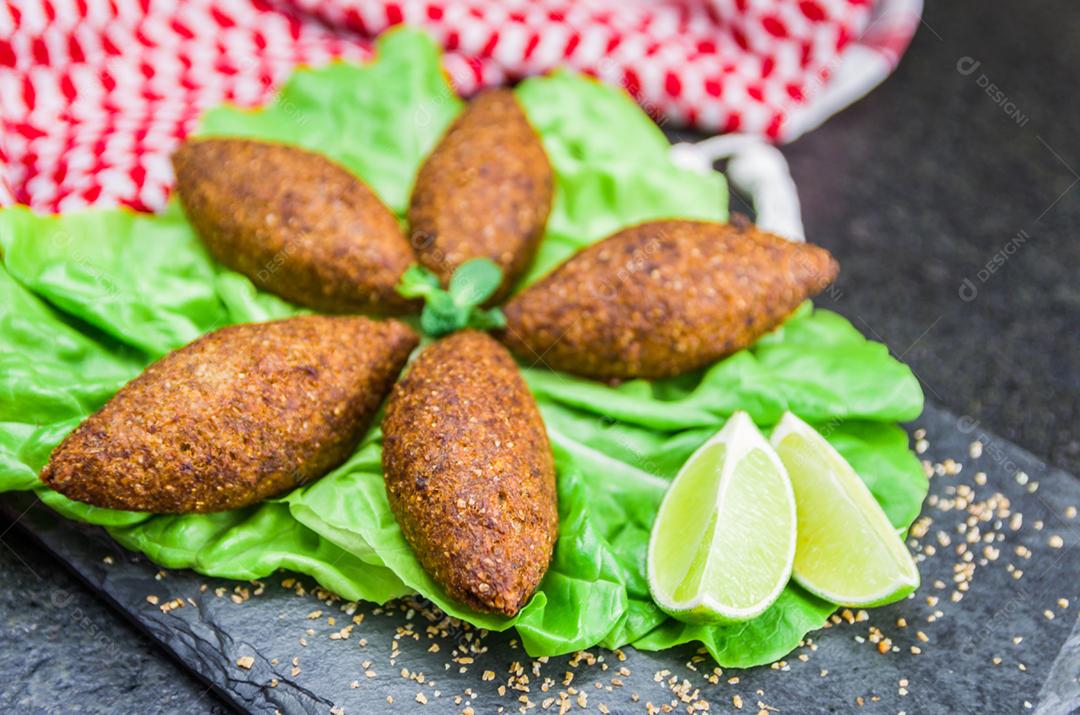 Deliciosa comida libanesa (árabe), quibe (kibe) com molhos e limão na pedra ardósia