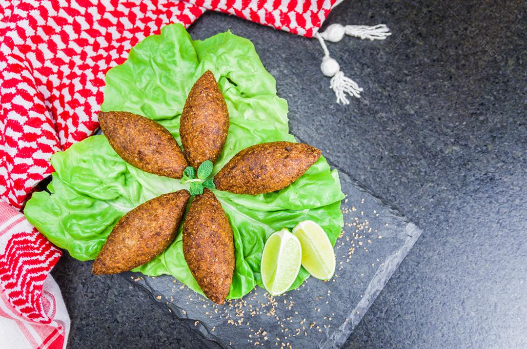 Deliciosa comida libanesa (árabe), quibe (kibe) com molhos e limão na pedra ardósia