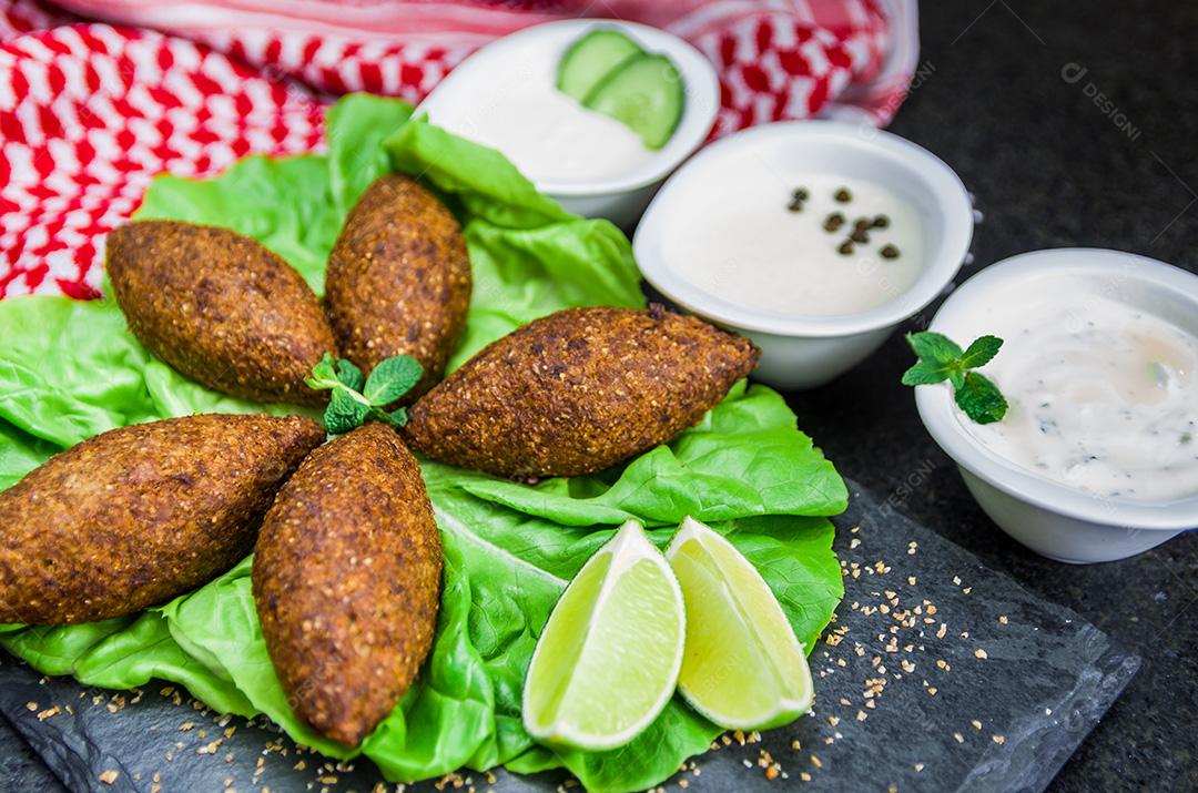 Deliciosa comida libanesa, quibe (kibe) com molhos e limão