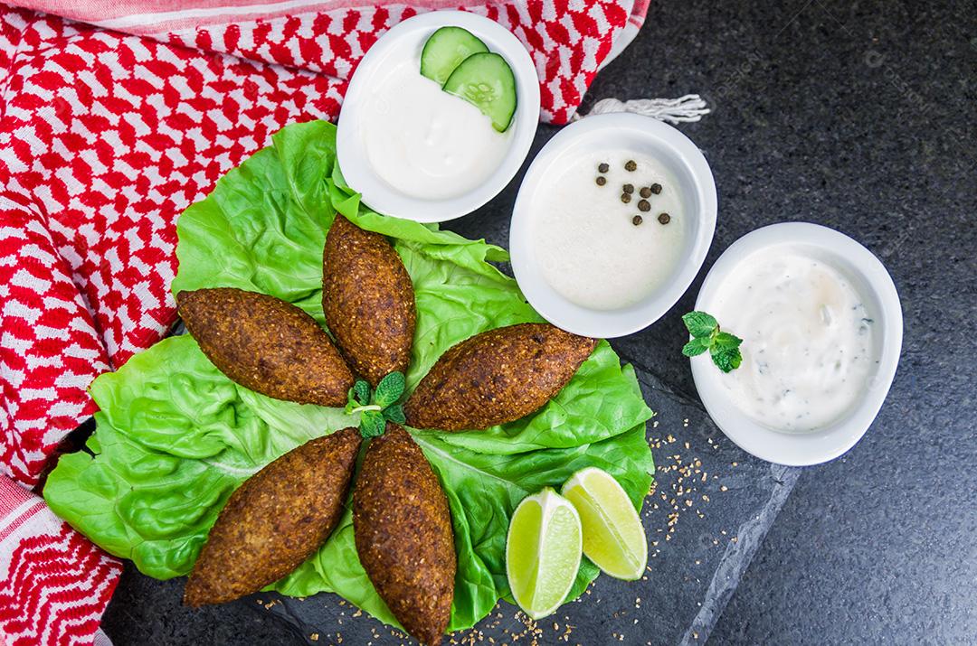 Deliciosa comida libanesa, quibe (kibe) com molhos e limão