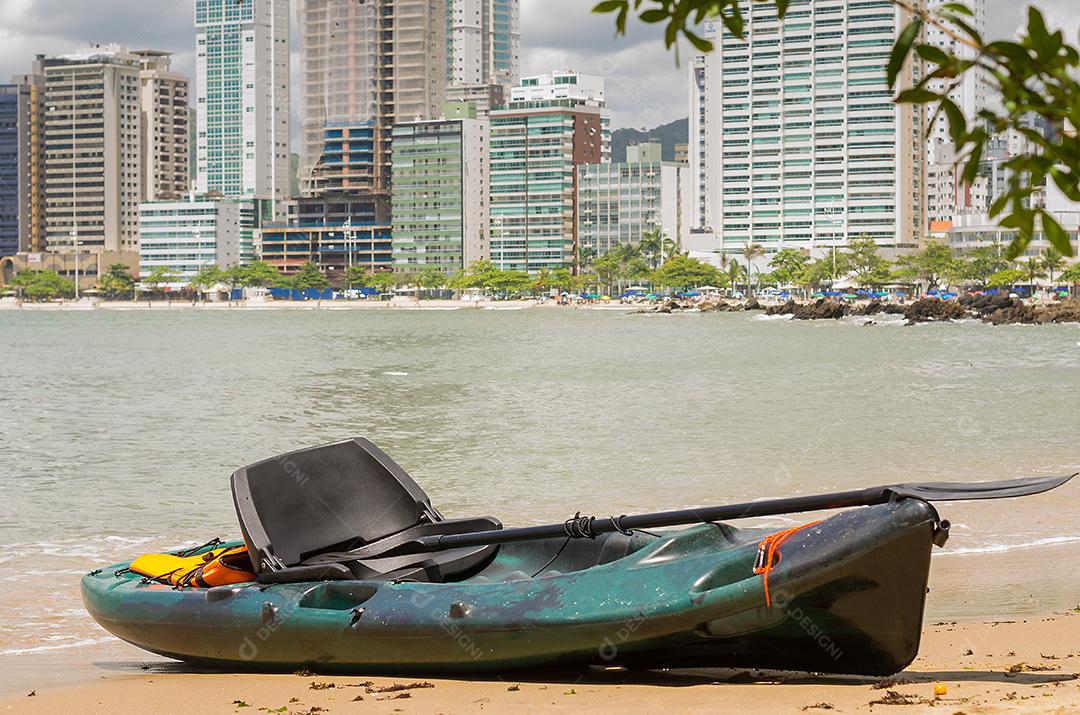 Grande conceito de férias, caiaque na areia, mar ao fundo