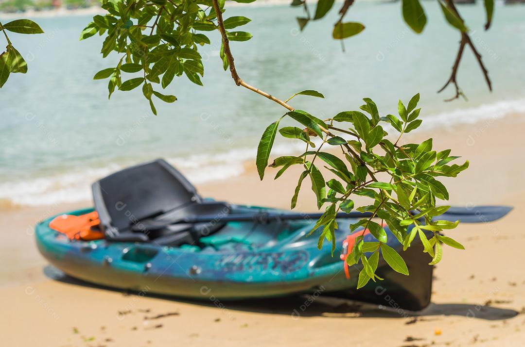 Grande conceito de férias, caiaque na areia, mar ao fundo