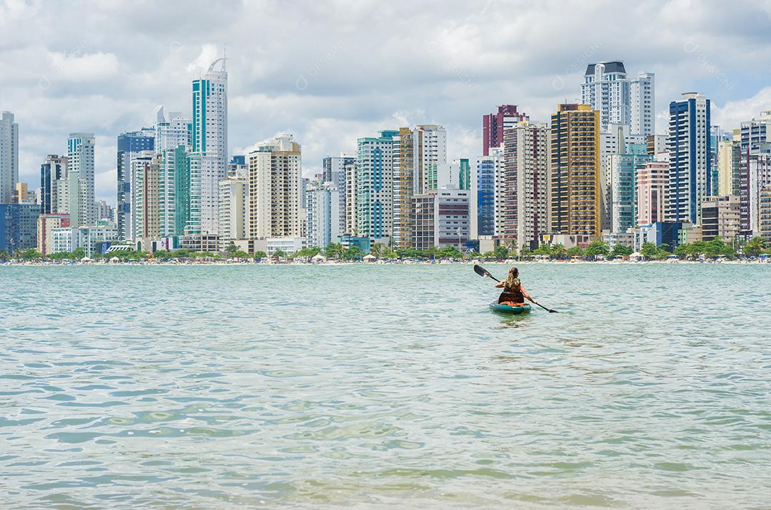 Jovem passeando de caiaque na praia brasileira. Pesca de caiaque