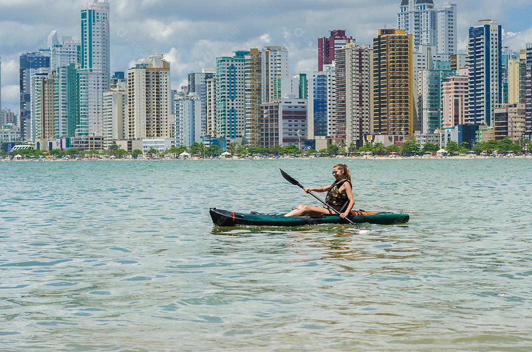 Jovem passeando de caiaque na praia brasileira. Pesca de caiaque