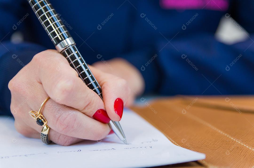 Close-up do bloco de notas e mulher de negócios escrevendo