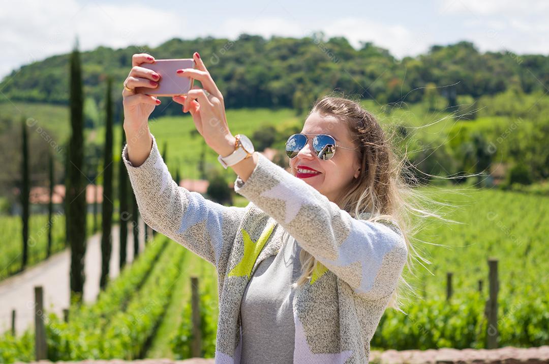 Jovem mulher tomando selfie, fotografando-se em ponto turístico