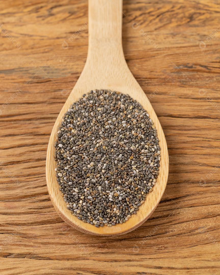 Sementes de chia em uma colher sobre a mesa de madeira